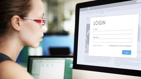 Junge Frau vor Computermonitor mit Login-Fenster