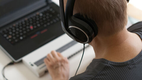 Mann am PC-Arbeitsplatz mit Braille-Tastatur
