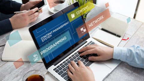 Mann am Laptop beim Arbeiten mit einem Redaktionssystem