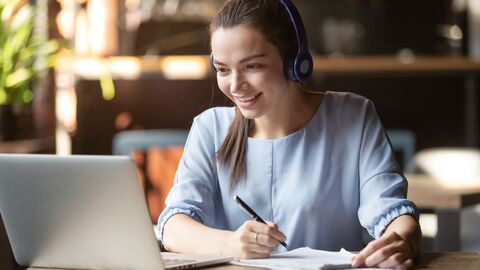 Junge Frau am Laptop beim digitalen Lernen 