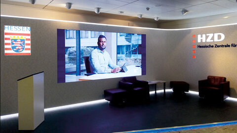Blick auf die LED-Wand im Foyer der HZD, auf dem das Kampagnenvideo mit Surenthar Santhirasegaran läuft