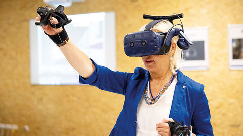 Digitalministerin Prof. Dr. Kristina Sinemus auf Sommerreise. In zahlreichen Unternehmen, öffentlichen Einrichtungen und Vereinen informierte sie sich über die unterschiedlichen Aspekte der Digitalisierung – von der Verwaltungsdigitalisierung über Künstliche Intelligenz bis hin zum Infrastrukturausbau. Prof. Dr. Kristina Sinemus, die auf einer Sommerreise eine VR-Brille ausprobiert