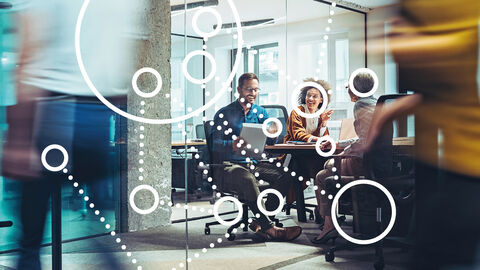 Menschen am Besprechungstisch mit darübergelegter Grafik aus Kreisen und Punkten, die ganzheitliches Projektmanagement symbolisiert