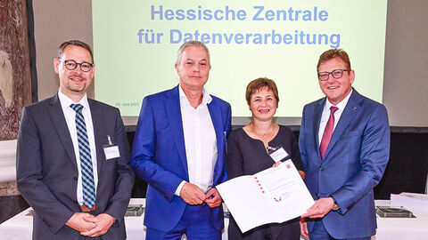 Übergabe der Verleihungsurkunde des Gütesiegels „Familienfreundlicher Arbeitgeber“ durch Staatssekretär Stefan Sauer an die HZD, die durch drei Personen vertreten wird