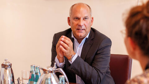 Prof. Dr. Roman Poseck am Schreibtisch im Gespräch mit der INFORM-Chefredakteurin