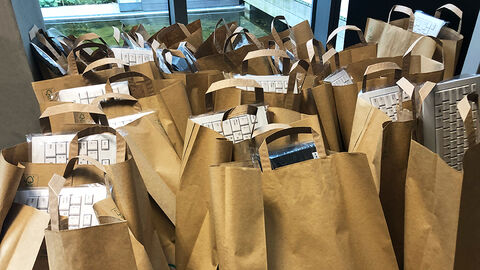 Close-up auf eine große Ansammlung brauner Papiertüten, aus denen Computertastaturen herausragen