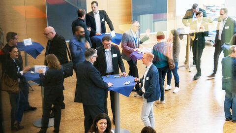 Blick in den großen Konferenzraum der HZD, bei dem die Teilnehmenden des Kundenforums Cloud-Transformation sich an Stehtischen in lockerer Gruppierung austauschen