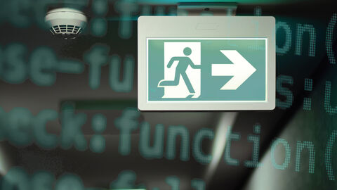 Großaufnahme eines Notausgangsschilds neben einem Rauchmelder, unscharf dahinter gelegt eine Grafik aus Programmierbefehlen