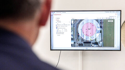 Blick am Kopf von Boris Rhein vorbei auf einen Computerscreen, auf dem das Interface des Programms zur elektronischen Aufenthaltsüberwachung zu sehen ist