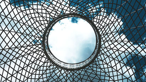 Kreisförmiger Spiegel, der den Himmel in einer Metallstruktur reflektiert