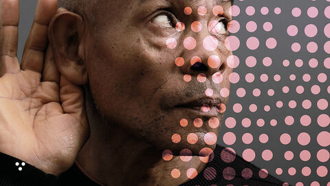 Close-up auf Mann im Halbprofil, der zum besseren Hören die gewölbte Hand ans Ohr gelegt hat