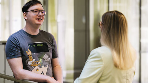 Junger Mann beim Gespräch mit Personalexpertin im Atrium der HZD