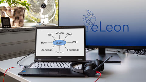 Blick auf einen Arbeitsplatz im Homeoffice, auf dessen Monitoren das eLeon Logo und eine Übersicht der angebotenen Kursbausteine zu sehen sind