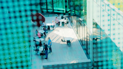 Blick von oben auf die Cafeteria-Terrasse der HZD, wo Mitarbeitende ihre Pause verbringen