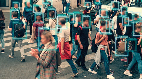 Zebrastreifen mit einer großen Gruppe von Menschen, über die Gesichter gelegt blaue Rahmen mit Angaben zur Identifizierung der Personen aus Überwachungssoftware
