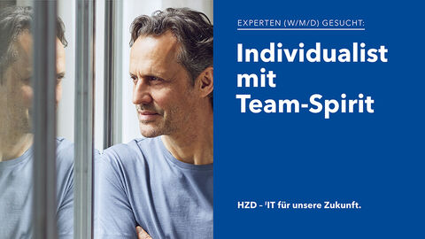 Porträt eines sympathisch aussehenden IT-Experten mit grau melierten Haaren und legerem blauem Shirt