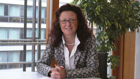 Frau sitzt an Schreibtisch 