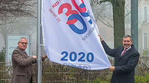 Zwei Männer hissen Flaggen