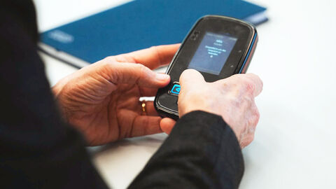 Close-up auf die Hände einer Frau, die auf das Display des Opfergeräts tippt