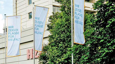 Close-up auf drei gehisste Diversity-Flaggen vor der HZD-Zentrale