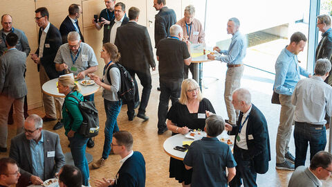 Blick in den großen Konferenzraum der HZD, bei dem sich Teilnehmende des Kundenforums Cloud während einer Pause an Stehtischen austauschen